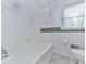 Bathroom with white tile walls, a window, and neutral tile floors at 4307 Smithsonia Ct, Tucker, GA 30084