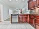 Kitchen area with stainless steel dishwasher, dark wood cabinetry, and granite countertops at 4307 Smithsonia Ct, Tucker, GA 30084