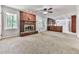 Bright living room featuring a brick fireplace, ceiling fan, and open access to kitchen at 4307 Smithsonia Ct, Tucker, GA 30084