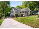 Charming home with a well-maintained lawn, inviting front porch, and a long driveway leading up to the house at 1084 Regent Sw St, Atlanta, GA 30310