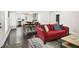 Open-concept living room with dark floors, a large red sofa, leading to a kitchen and dining area at 1084 Regent Sw St, Atlanta, GA 30310