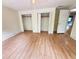 Bedroom with hardwood flooring, a door leading to a bathroom, and open closets at 1794 Blossom Ln, Austell, GA 30168