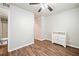 A bright bedroom with a ceiling fan features a door and a white dresser on a hardwood floor at 200 High Creek Dr, Roswell, GA 30076