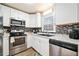 Stylish kitchen featuring white cabinets, black hardware, and stainless steel appliances at 200 High Creek Dr, Roswell, GA 30076