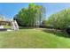 Spacious backyard with a stairway to the upper deck and mature trees at 562 Grassmeade Way, Snellville, GA 30078