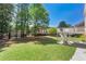 Large, well-maintained backyard with mature trees and a stairway to a deck at 562 Grassmeade Way, Snellville, GA 30078