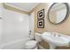 Cozy bathroom featuring a tub, toilet, and pedestal sink at 562 Grassmeade Way, Snellville, GA 30078