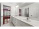 Bright bathroom featuring double sinks with vanity and large mirror, and entry to pink bedroom at 562 Grassmeade Way, Snellville, GA 30078