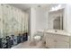White bathroom featuring a shower with a floral curtain, a sink with vanity, and a toilet at 562 Grassmeade Way, Snellville, GA 30078