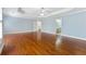 Spacious bedroom with hardwood floors, blue walls, white trim, a tray ceiling, and access to the bathroom at 562 Grassmeade Way, Snellville, GA 30078