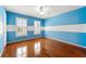 A blue and white striped bedroom with hardwood floors, ceiling fan, and a window with shuttered blinds at 562 Grassmeade Way, Snellville, GA 30078