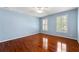 Light blue bedroom featuring hardwood floors, ceiling fan, and two windows with shuttered blinds at 562 Grassmeade Way, Snellville, GA 30078
