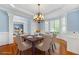 Elegant dining room featuring hardwood floors, crown molding, and a stylish chandelier above the dining table at 562 Grassmeade Way, Snellville, GA 30078