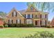 Elegant brick home with manicured lawn and mature landscaping offers great curb appeal at 562 Grassmeade Way, Snellville, GA 30078