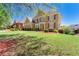 A beautiful brick home with lush green lawn and landscape, creating a welcoming curb appeal at 562 Grassmeade Way, Snellville, GA 30078