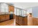 Kitchen featuring dark countertops, wood cabinets, and hardwood floors at 562 Grassmeade Way, Snellville, GA 30078