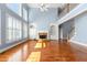 Inviting living room with a stone fireplace, hardwood floors, high ceilings, and large windows at 562 Grassmeade Way, Snellville, GA 30078
