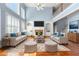 Spacious living room featuring a cozy fireplace, high ceilings, large windows, and hardwood floors at 562 Grassmeade Way, Snellville, GA 30078