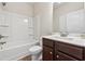 Clean, standard bathroom with a shower-tub combo, white vanity, and wooden-look flooring at 1543 Dover Creek Ln, Lawrenceville, GA 30045