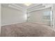 Spacious bedroom with a tray ceiling, neutral carpeting, and ample natural light from the windows at 1543 Dover Creek Ln, Lawrenceville, GA 30045