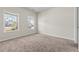 Empty bedroom with neutral carpet, natural light, and view of houses through the windows at 1543 Dover Creek Ln, Lawrenceville, GA 30045