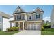 Attractive two-story home featuring a stone and gray exterior, enhanced by dark shutters and a neatly kept lawn at 1543 Dover Creek Ln, Lawrenceville, GA 30045