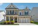 Charming two-story home boasts a stone and gray facade, complemented by black shutters and a well-manicured front yard at 1543 Dover Creek Ln, Lawrenceville, GA 30045