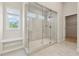 Walk-in shower with glass enclosure, built-in bench, and tiled walls in the primary bathroom at 1543 Dover Creek Ln, Lawrenceville, GA 30045