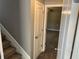Carpeted staircase leading to a bright bedroom with a ceiling fan, showcasing the home's layout at 202 Gamel Rd, Dallas, GA 30157