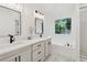 Bright bathroom features a double vanity, quartz countertops, and a luxurious soaking tub with jets at 290 Magnolia Walk Ln, Atlanta, GA 30349