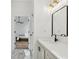 Hallway view of bath features matte black fixtures, quartz countertops and a mirror at 290 Magnolia Walk Ln, Atlanta, GA 30349