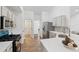 This kitchen features stainless steel appliances, bright white cabinets and updated backsplash at 290 Magnolia Walk Ln, Atlanta, GA 30349