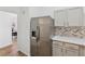 Modern kitchen with stainless steel refrigerator, white cabinets and granite countertops at 290 Magnolia Walk Ln, Atlanta, GA 30349