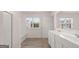 Light-filled bathroom featuring double sinks, tiled floor, and a large window at 315 Silver Moon Dr, Loganville, GA 30052