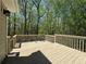 Large wooden deck with ample space for outdoor seating overlooking a wooded area at 5668 Blanchard Pl, Sugar Hill, GA 30518