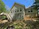 Exterior view showing back of house with walk out basement and wooden stairs and deck at 5668 Blanchard Pl, Sugar Hill, GA 30518