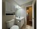 Bathroom with toilet, sink, and doorway to hall at 5668 Blanchard Pl, Sugar Hill, GA 30518