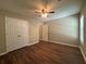 Bedroom showcasing hardwood floors, a ceiling fan, and double-door closet at 5668 Blanchard Pl, Sugar Hill, GA 30518
