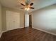 Bedroom features wood floors, a ceiling fan, and double-door closet at 5668 Blanchard Pl, Sugar Hill, GA 30518