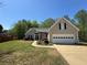 Beautiful single-Gathering home featuring a well-manicured lawn and attached two-car garage at 5668 Blanchard Pl, Sugar Hill, GA 30518