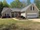 Inviting single-Gathering home featuring a well-manicured lawn and attached two-car garage at 5668 Blanchard Pl, Sugar Hill, GA 30518