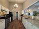 Modern kitchen with stainless steel appliances, granite countertops, white cabinets and tile backsplash at 5668 Blanchard Pl, Sugar Hill, GA 30518