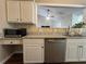 Kitchen featuring stainless steel dishwasher and microwave, granite countertops, and white cabinets at 5668 Blanchard Pl, Sugar Hill, GA 30518