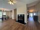 Inviting living room with dark wood floors, cozy fireplace, ceiling fan, and access to the breakfast nook at 5668 Blanchard Pl, Sugar Hill, GA 30518