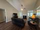 Cozy living room with a fireplace, ceiling fan, and wood-look flooring throughout the space at 5668 Blanchard Pl, Sugar Hill, GA 30518