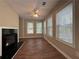 Bright living room featuring a fireplace, ceiling fan, wood floors and large windows providing backyard views at 5668 Blanchard Pl, Sugar Hill, GA 30518