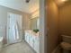 Bright bathroom featuring dual sinks, tile floors, and a white towel hanging on the door at 5668 Blanchard Pl, Sugar Hill, GA 30518