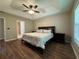Comfortable main bedroom featuring dark wood floors, a trey ceiling, ceiling fan, and a king size bed at 5668 Blanchard Pl, Sugar Hill, GA 30518