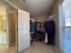 Bright walk-in closet featuring tile flooring, shelving and a window with blinds at 5668 Blanchard Pl, Sugar Hill, GA 30518