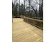 A spacious wooden deck with natural finish and wooden railings, ideal for outdoor entertainment and relaxation at 9290 Prestwick Club Dr, Johns Creek, GA 30097